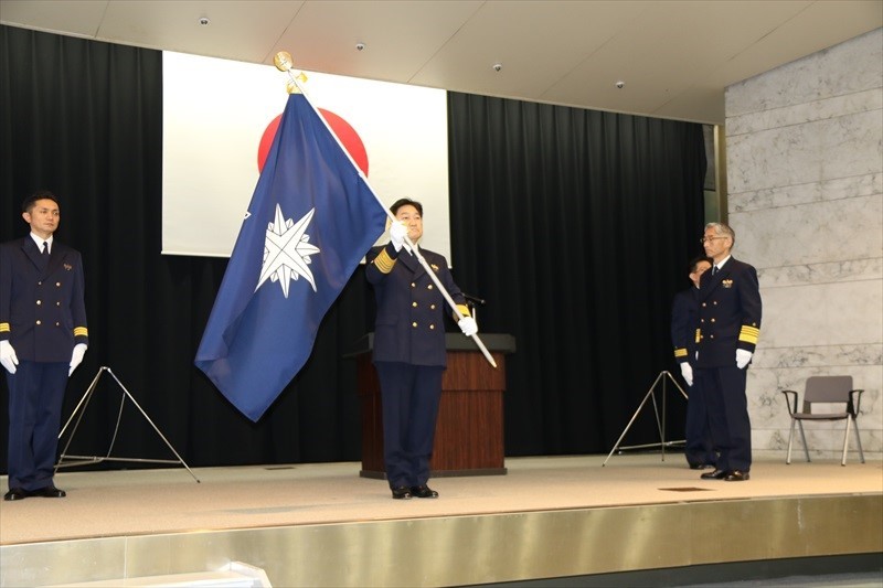 岩並前長官（右）から奥島新長官（左）への庁旗引継ぎ